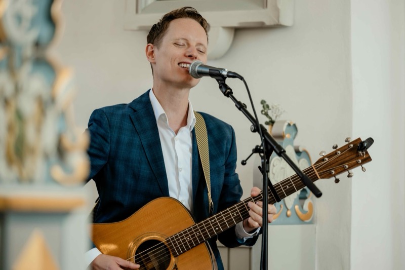 Jason synger og spiller guitar ved en kirkelig ceremoni